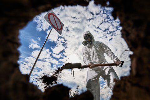 Ecologist Digging Pit By Shovel And Planting Tree In Polluted Area