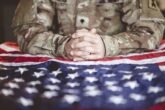 American Soldier Mourning And Praying With The American Flag In Front Of Him